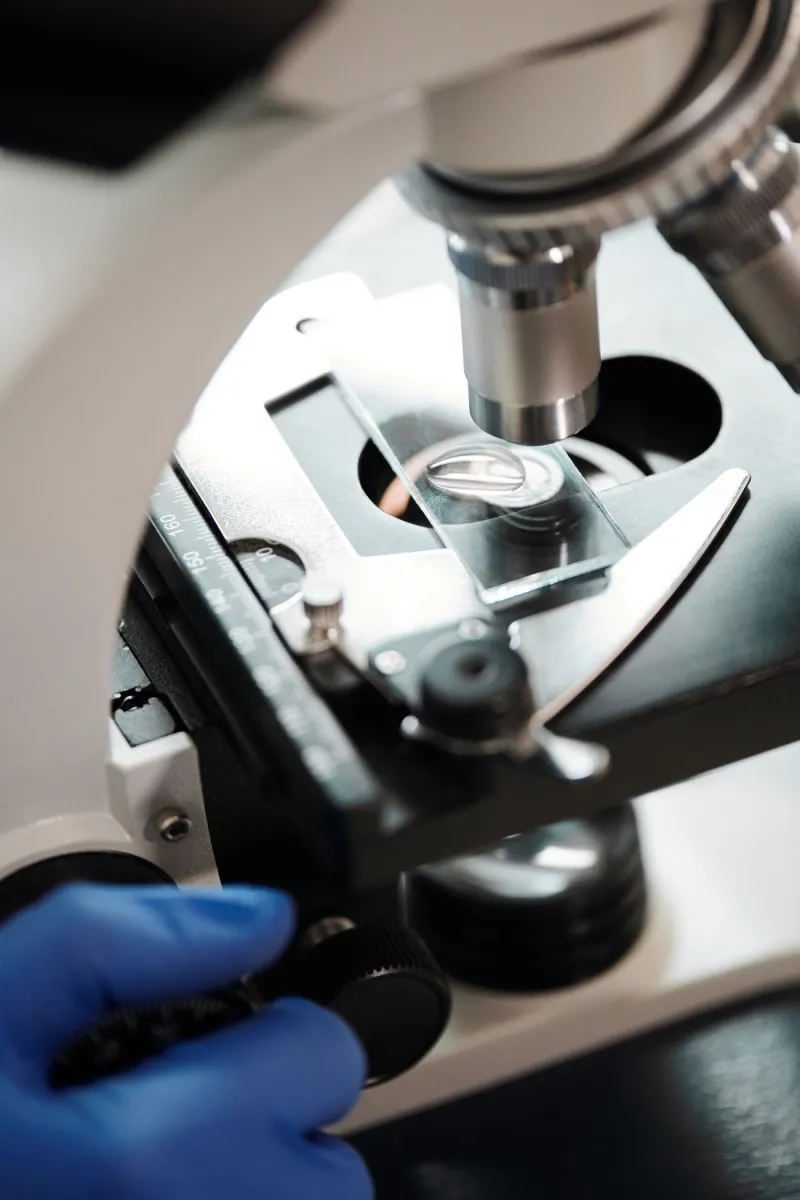 Detalle del objetivo de un microscopio sobre un portaobjetos